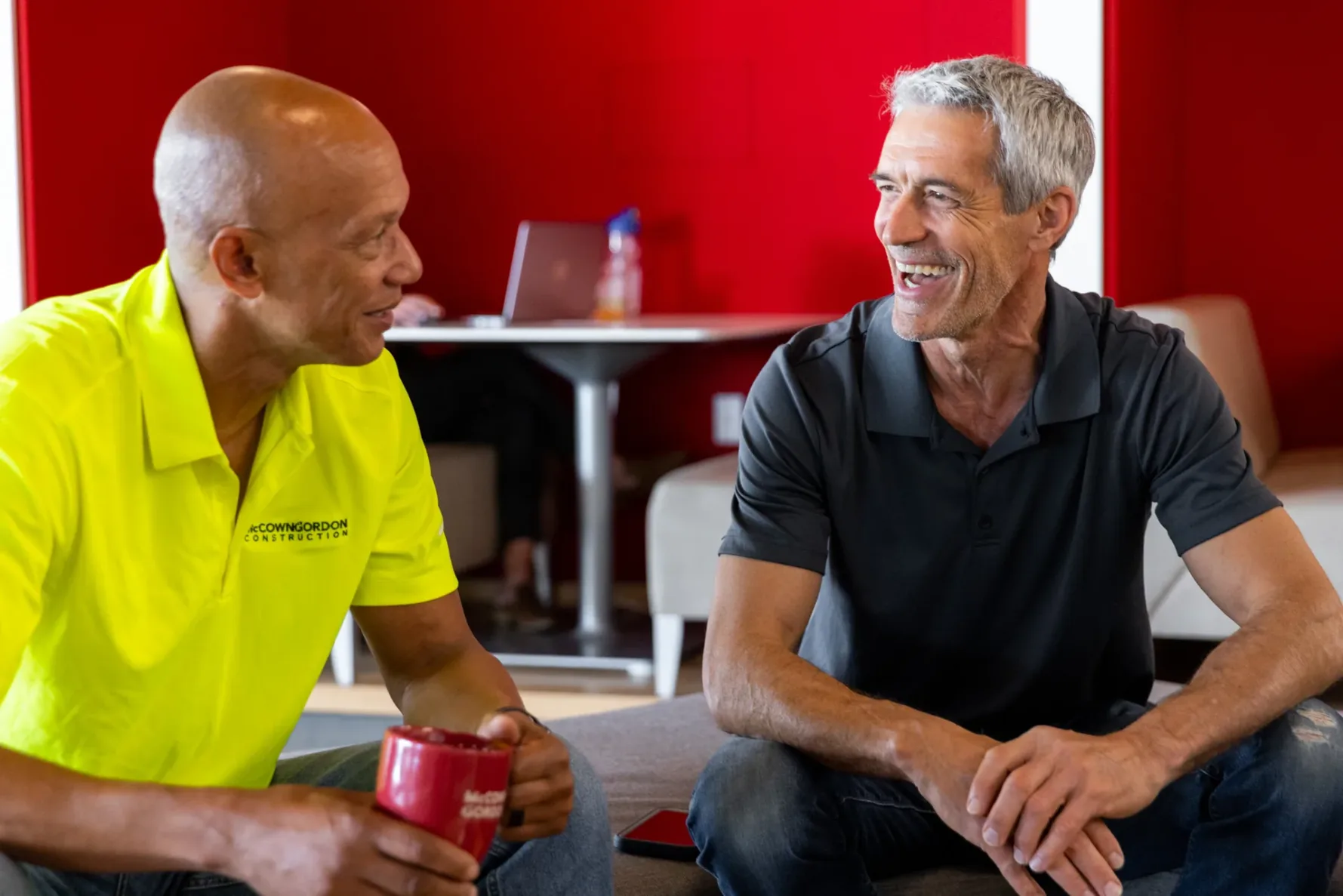 Two McCownGordon Construction associates laughing while collaborating in the office