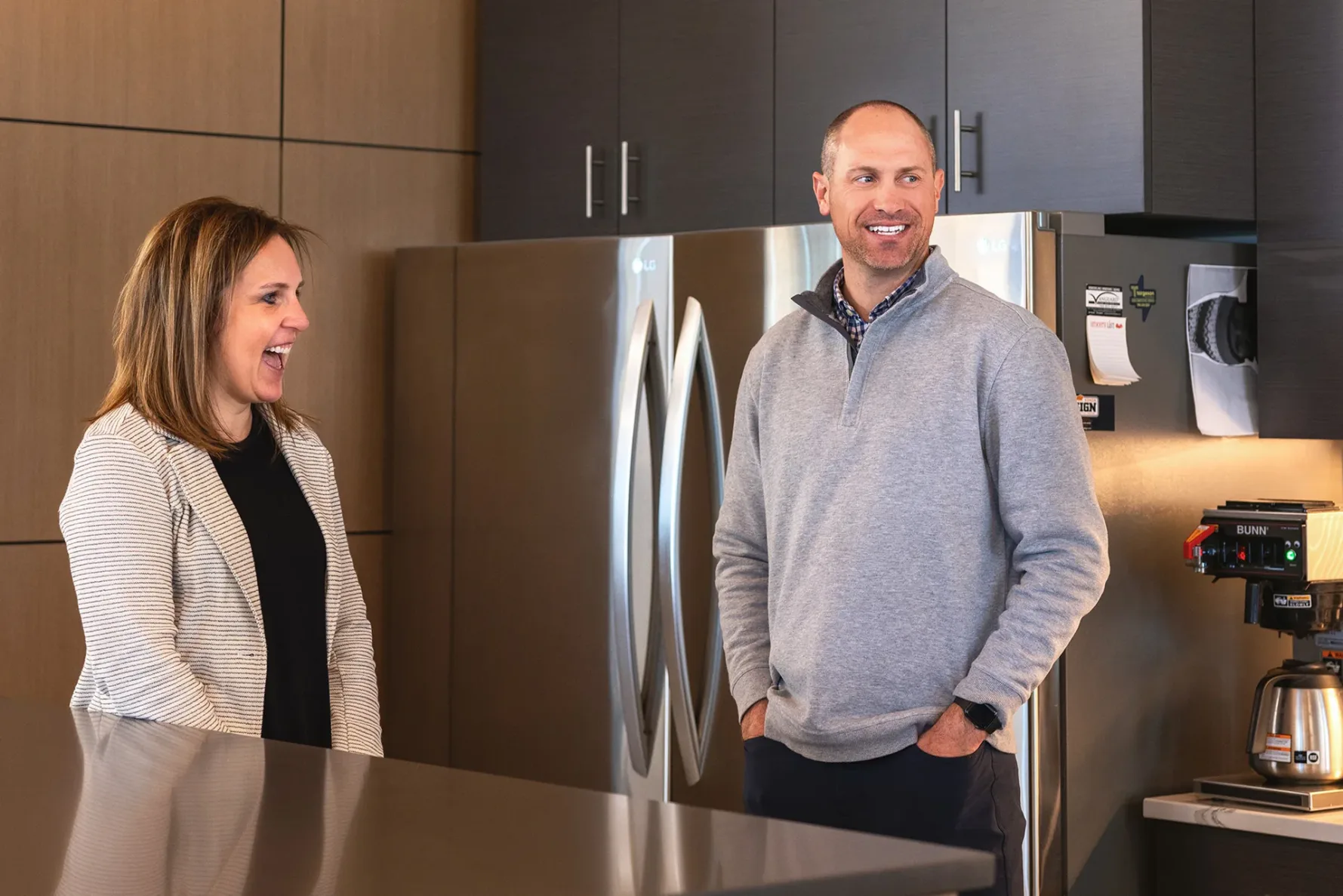 A man and woman laughing and talking in the break room at McCownGordon Construction