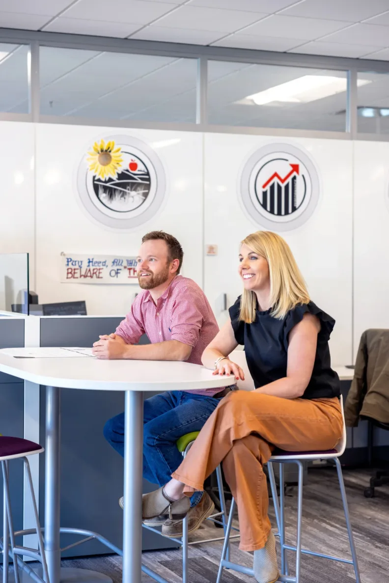 A man and woman laughing and talking at work