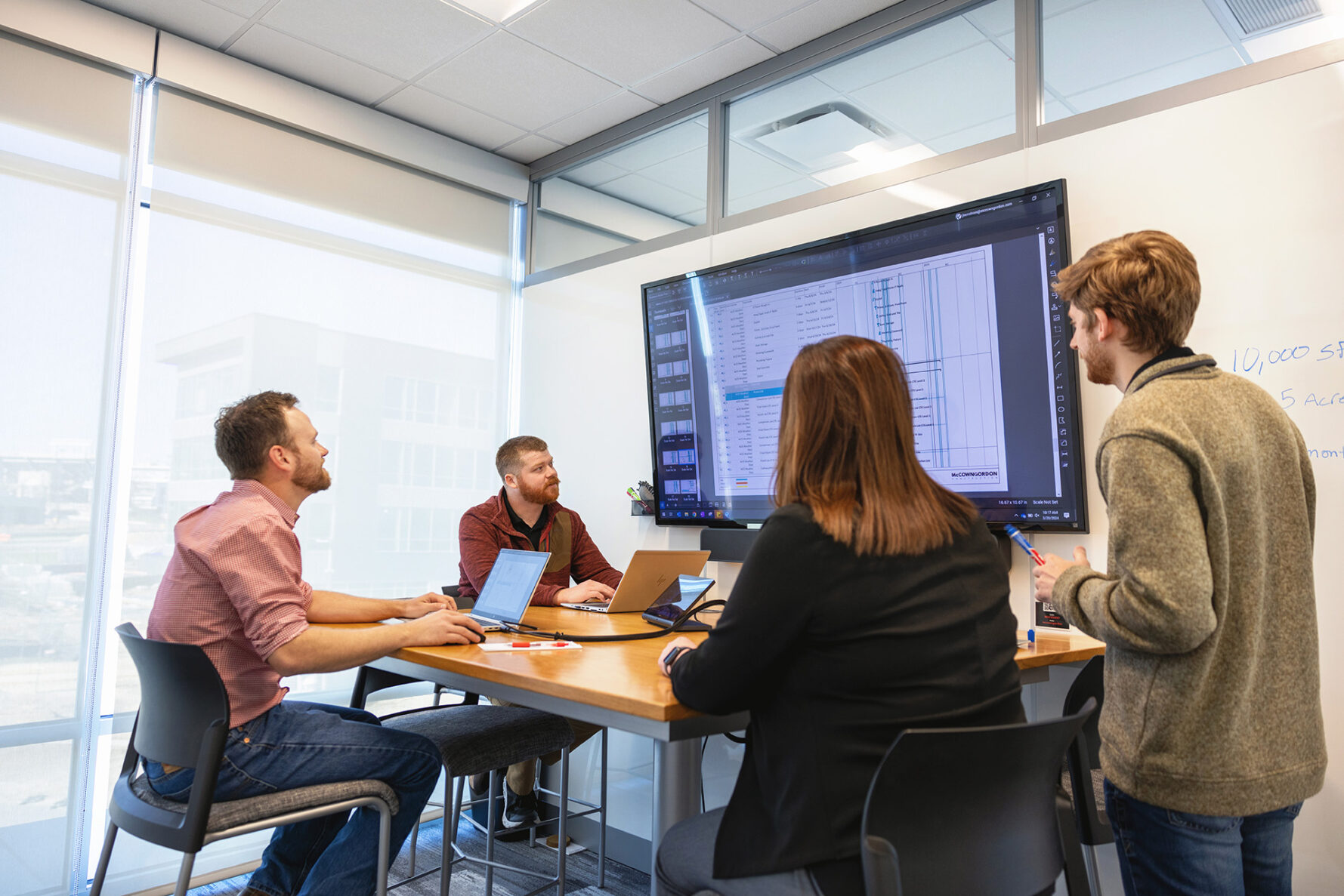 McCownGordon associates having a meeting and looking at a screen together.