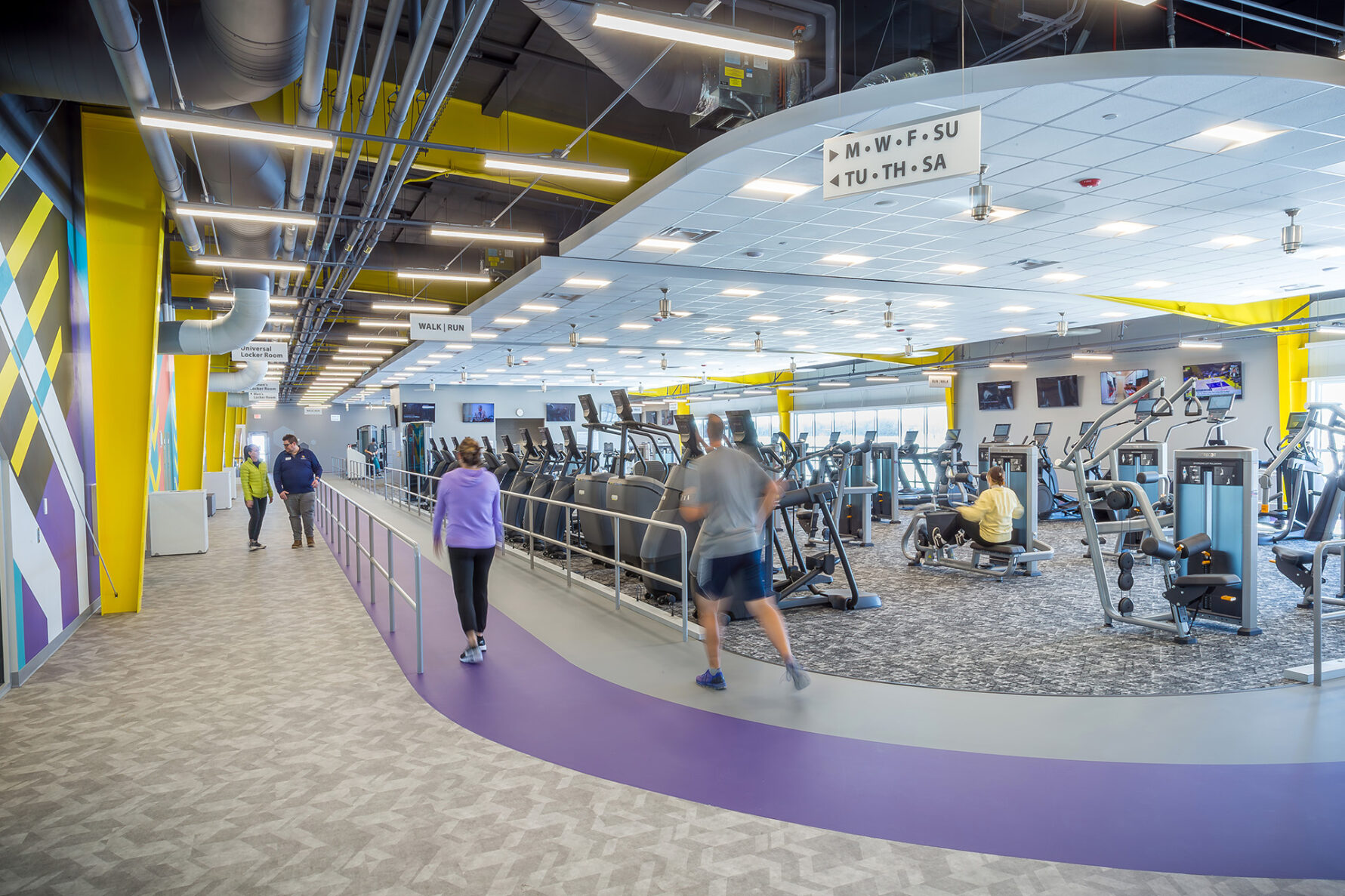 People walking on an indoor track around fitness equipment at the Valley Center Recreation Center